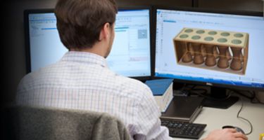 Employee working at a computer on a part that will be additive manufactured