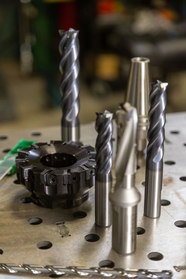 Group of WIDIA metal cutting tools including an indexable mill, solid end mills, tool holder, and drills