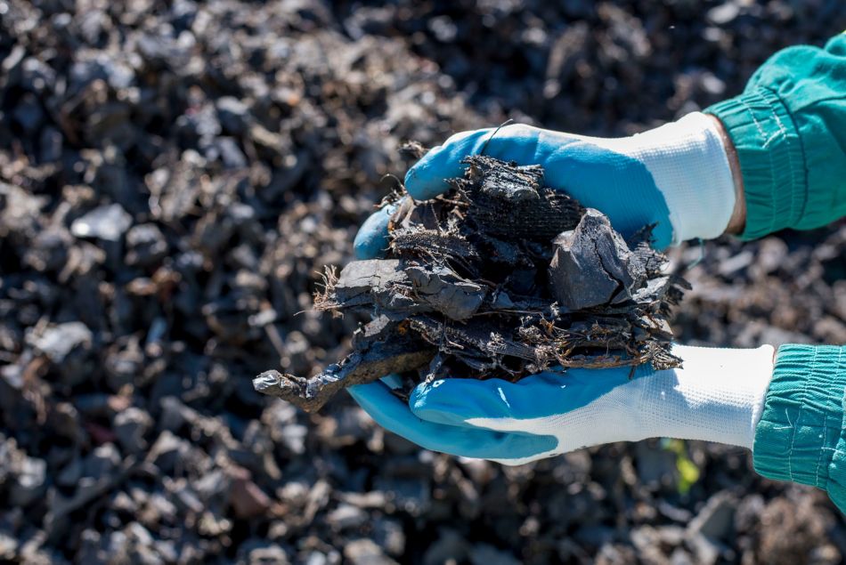 Hands holding pieces of shredded tires