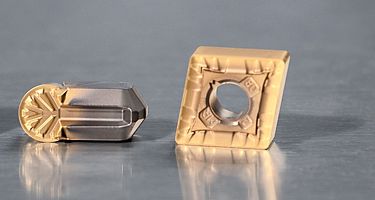 Three Kennametal turning inserts