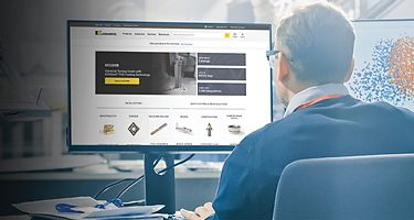 Man looking at Kennametal website on a computer monitor