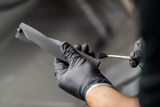 Man Holding Additive Manufacturing Component and Brush