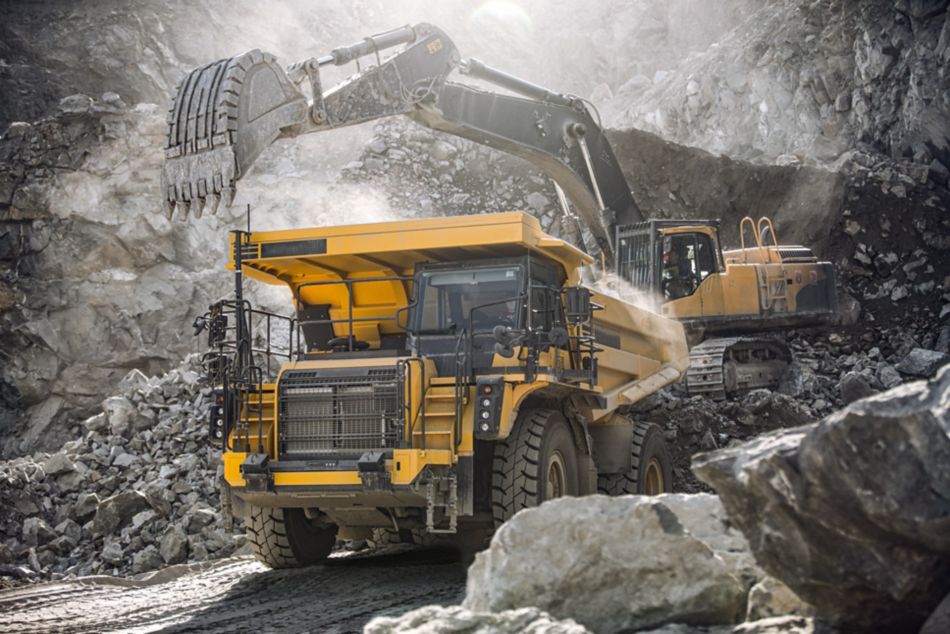 Yellow mining truck surrounded by rubble