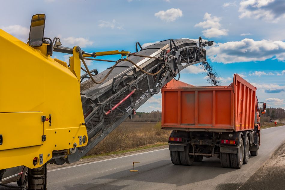 Road Milling Machine Throwing Milled Asphalt into a Dump Truck