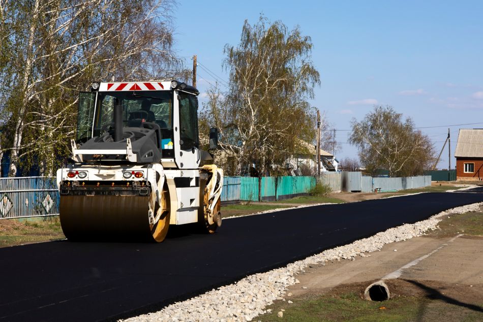 The road roller rolls fresh asphalt.