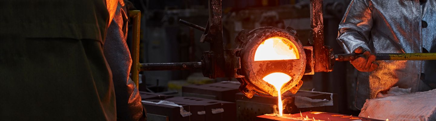 Sand casting process. Experts pouring hot material.