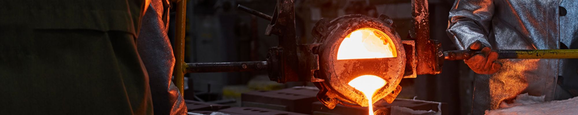 Sand casting process. Experts pouring hot material.