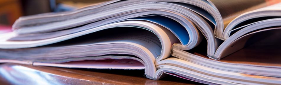 Stack of Catalogs on a Table Banner