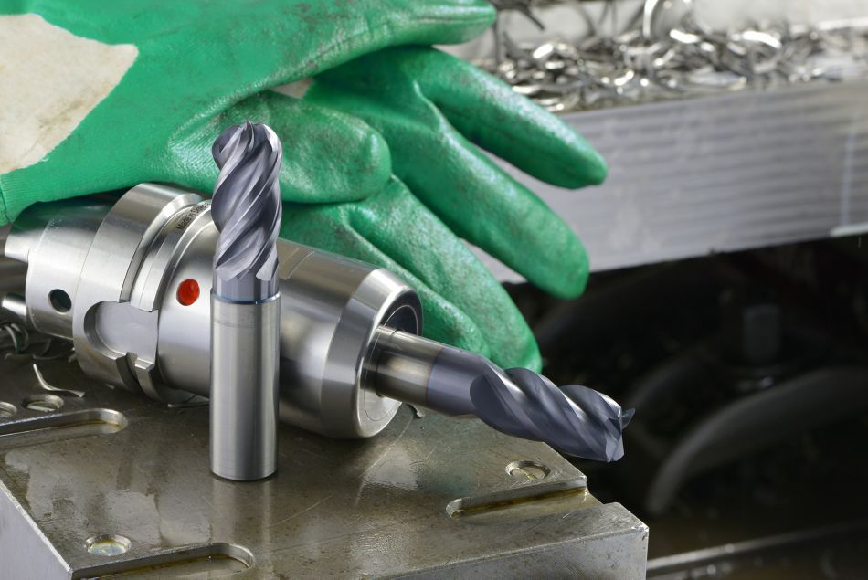 WIDIA WCE4 solid end mill, WCE4 in tool holder, gloves, and metal chips on a metal workpiece